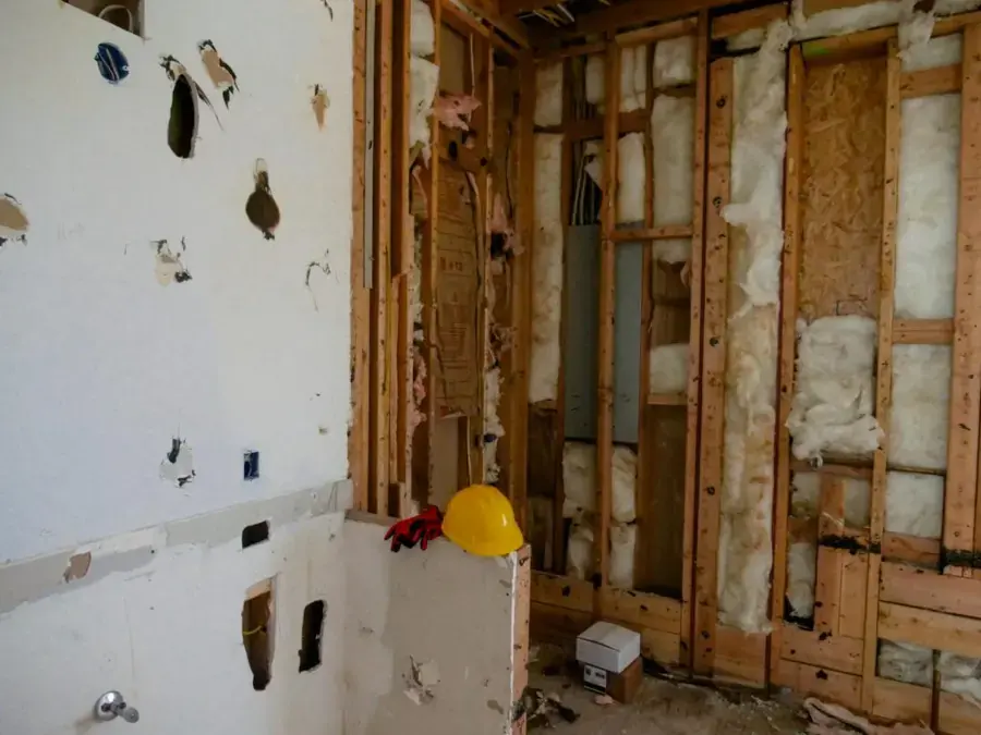 A wall opened to the studs with the insulation exposed for drying