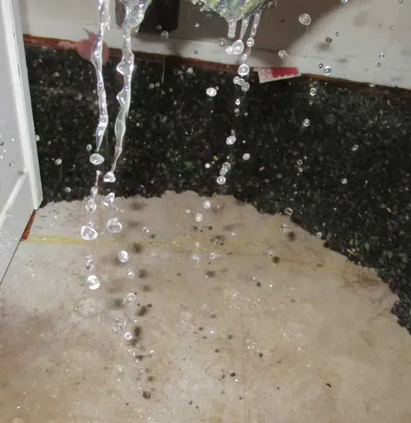 Water dripping from a leak overhead onto a granite countertop