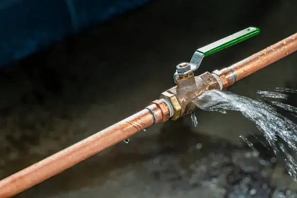 Water spraying from a failed valve on a copper supply pipe